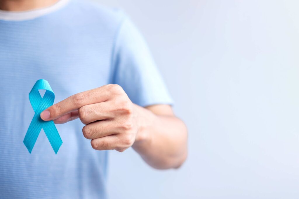 Homem segurando a fitinha do Novembro Azul que conscientiza sobre a sa&uacute;de masculina